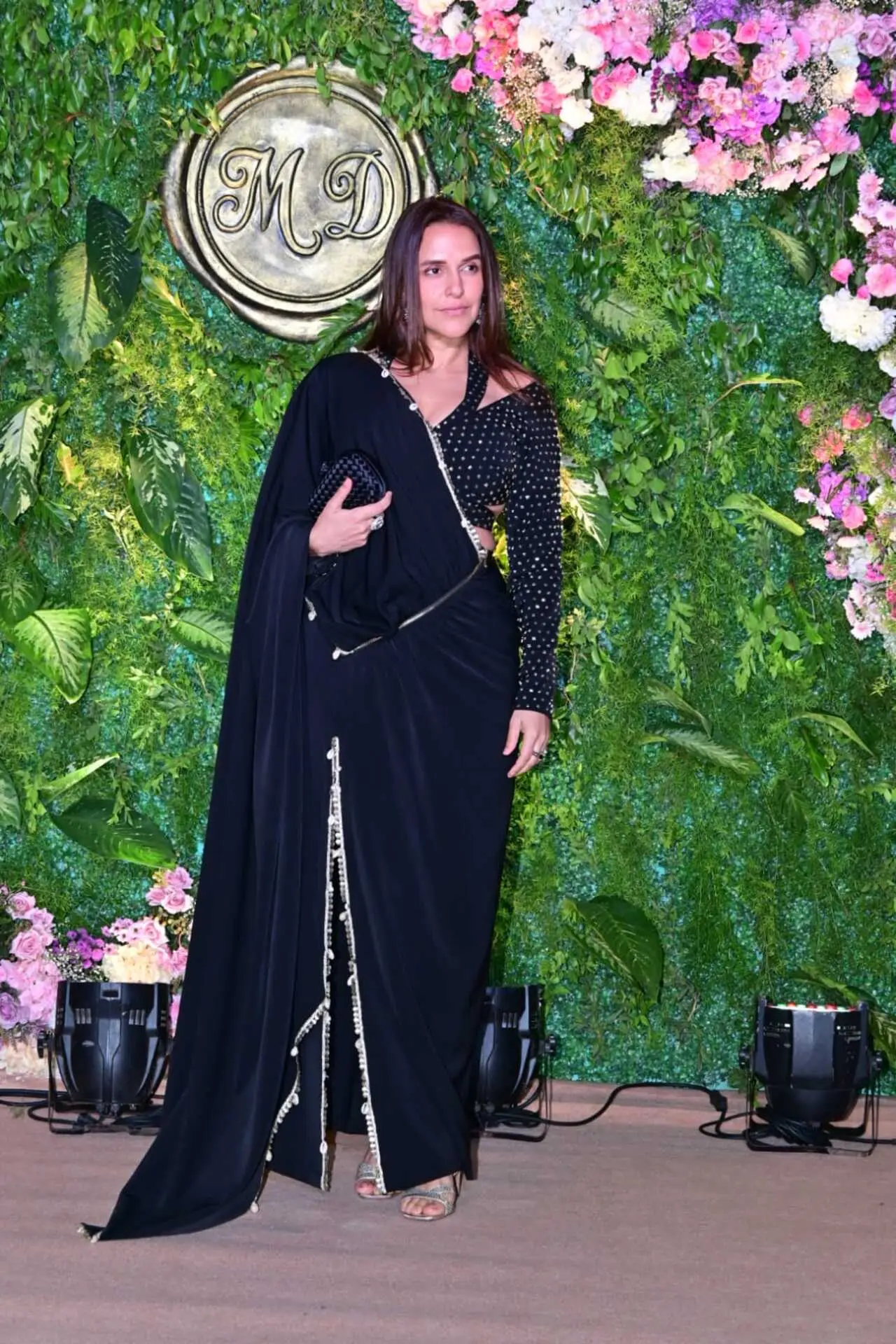 Neha Dhupia made a stylish appearance at the pre-wedding celebration in an elegant black saree ensemble. The actor paired the draped saree with a matching embellished blouse featuring subtle shimmer details.
